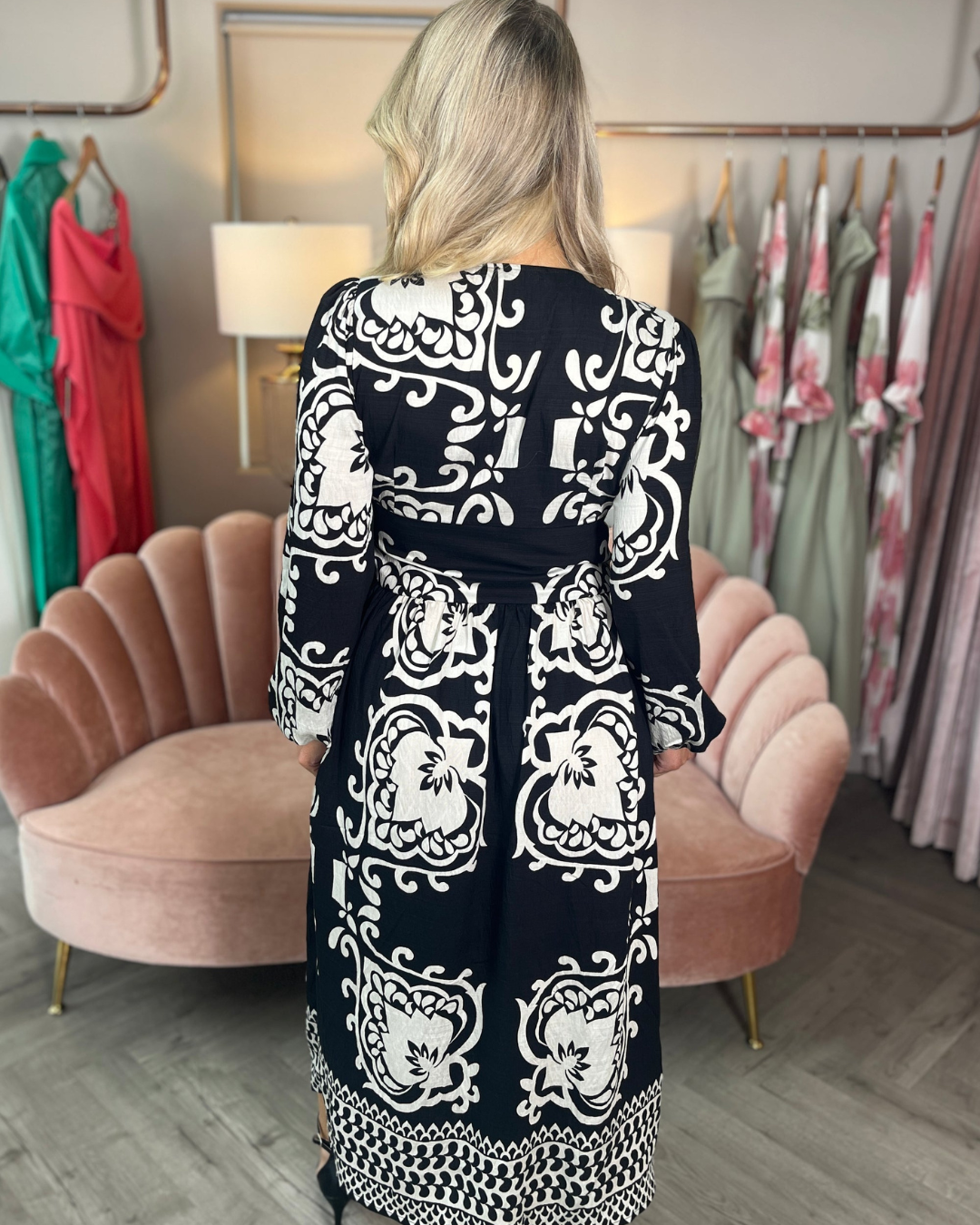 Vestido midi preto com estampado branco, decote cruzado e manga curta. 