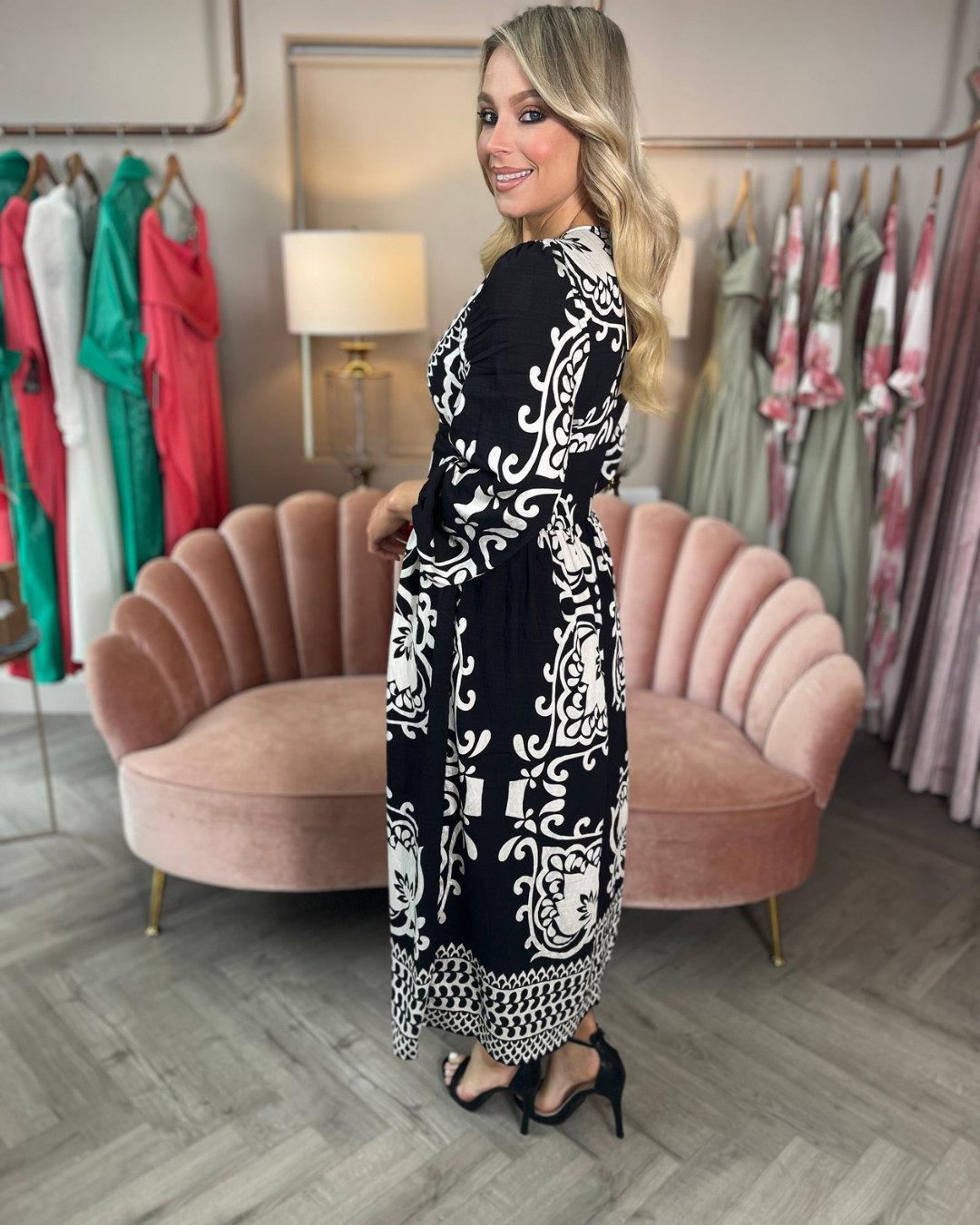 Vestido midi preto com estampado branco, decote cruzado e manga curta. 