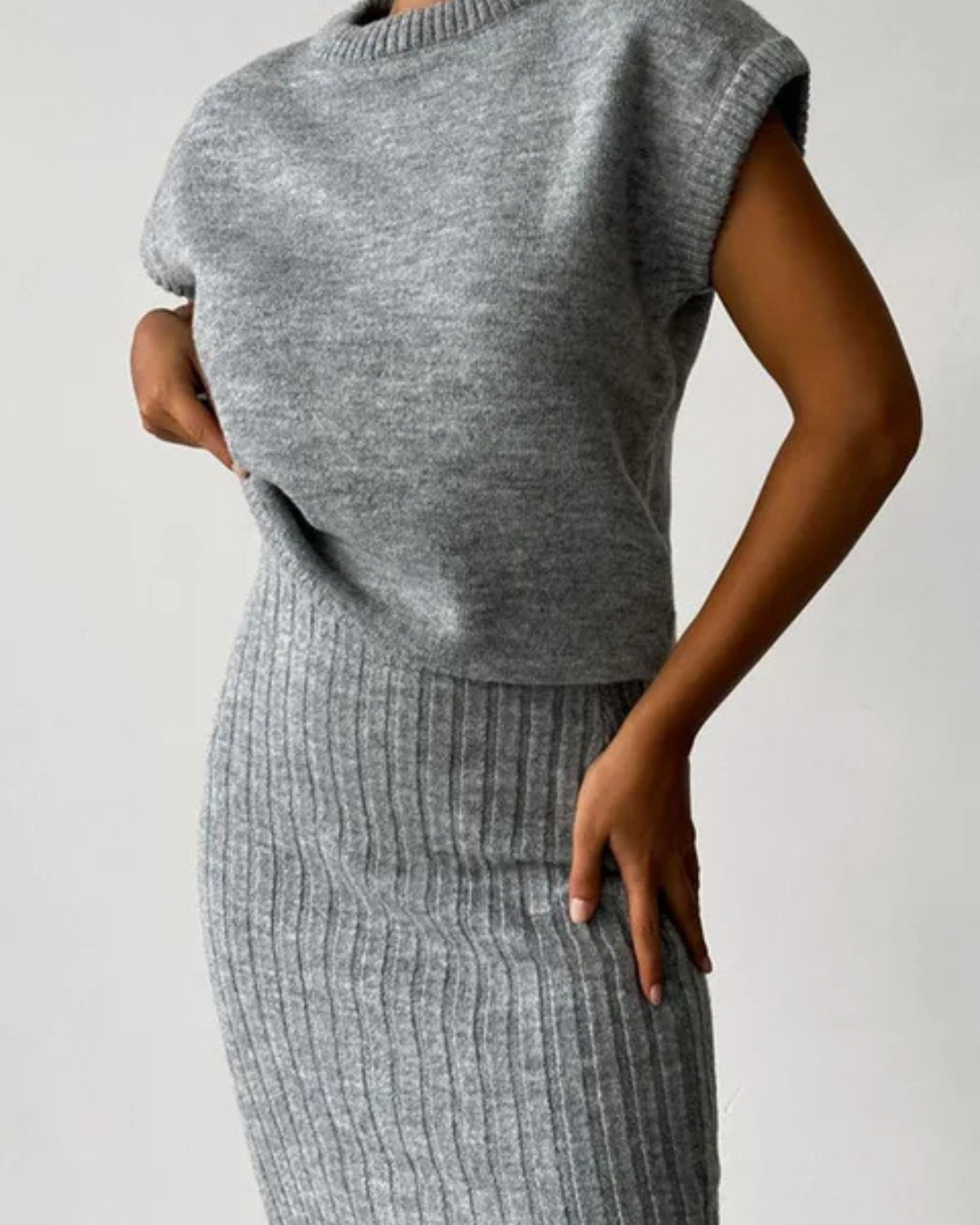 Conjunto de blusa sem mangas e saia comprida, exclusivo para mulher. 